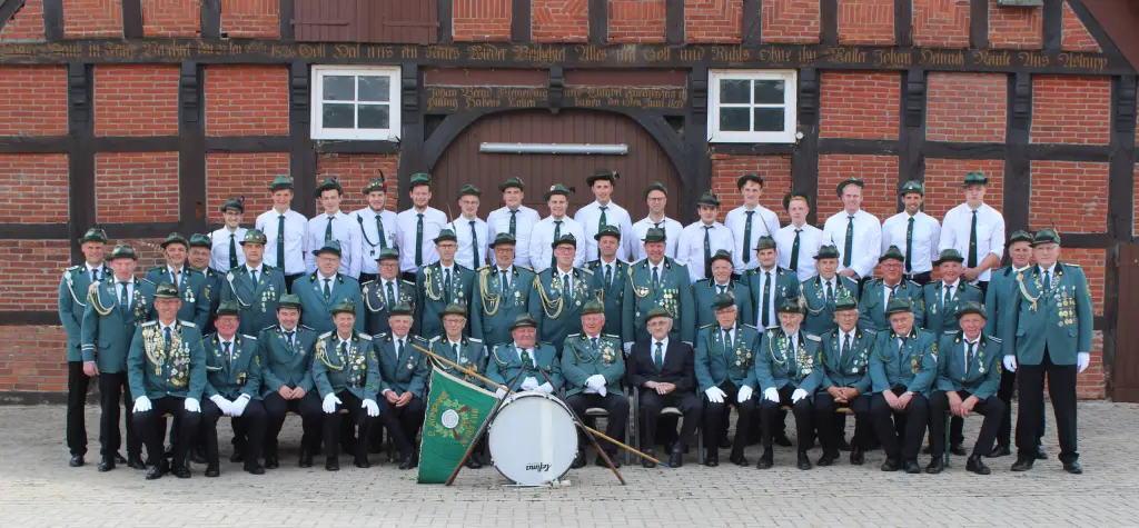 Gruppenfoto der II. Kompanie Bergfeine vor einem Fachwerkhaus, davor Fahne und große Trommel